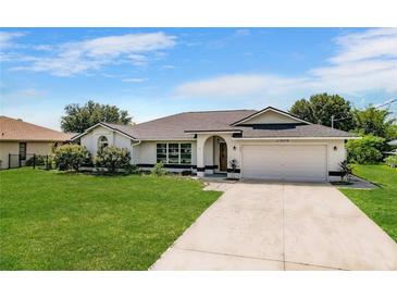 Charming single-story home featuring a well-maintained lawn and a spacious two-car garage at 7384 Van Lake Dr, Englewood, FL 34224