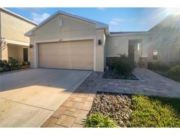 House exterior featuring a two-car garage and landscaped front yard at 6223 Springmont Loop, Palmetto, FL 34221