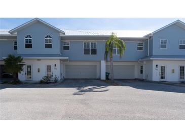 Front view of a light blue, two-story townhome with attached garage and palm trees at 3919 Cape Haze Dr # 503, Rotonda West, FL 33947