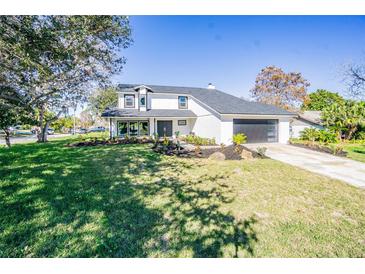 Charming two-story home with fresh landscaping, driveway, an attached garage and a well manicured lawn at 6370 Conniewood Sq, New Port Richey, FL 34653