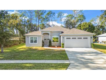 A beautiful one-story house with a two-car garage and landscaped yard at 5277 Epping Ln, Zephyrhills, FL 33541