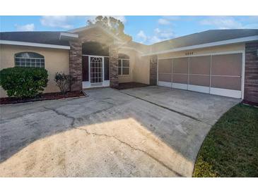 Brick house with a two-car garage and a screened entryway at 6844 Northlake Dr, Zephyrhills, FL 33542