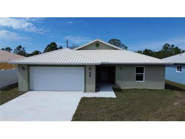 Charming single-story home featuring a two-car garage, well-maintained lawn, and modern metal roof at 12263 Cartouche Ave, Punta Gorda, FL 33955