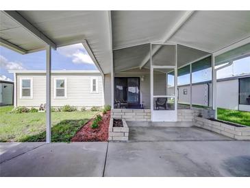 Covered screened porch with paver patio and landscaped area at 3145 Hidden Lake Dr, Wesley Chapel, FL 33543