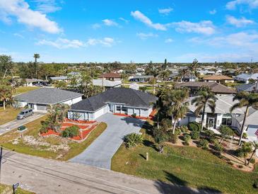 Spacious home featuring well-manicured landscaping, a wide driveway, and a charming neighborhood setting at 4367 Albacore Cir, Port Charlotte, FL 33948