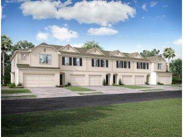 Front view of townhouses with attached garages and landscaping at 32094 Eastern Redbud Br, San Antonio, FL 33576