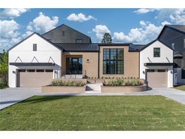 Modern two-story home with a black metal roof, brick and white siding, and a landscaped front yard at 1046 Snell Isle Ne Blvd, St Petersburg, FL 33704