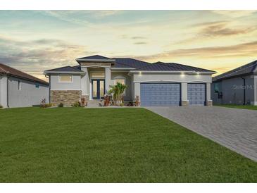 Modern two-story home with a three-car garage and lush green lawn at 243 Rotonda S Blvd, Rotonda West, FL 33947