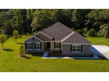 Charming two-story home with stone and siding accents, large front yard and lush landscape at 2550 Mauritania Rd, Punta Gorda, FL 33983