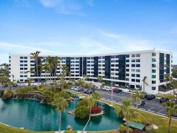 Beautiful waterfront condo building with lush landscaping and palm trees at 5855 Midnight Pass Rd # 108, Sarasota, FL 34242