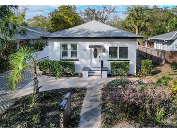 Charming white bungalow with landscaped yard and paved driveway at 603 W Emma St, Tampa, FL 33603