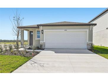 Charming one-story home with a two-car garage and well-maintained front yard landscaping at 14061 Crutchfield Ct, Parrish, FL 34219