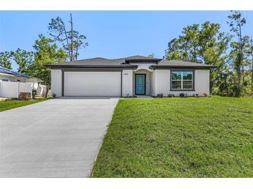 Inviting single-story home featuring a manicured lawn and a modern, two-car garage at 4495 Eldron Ave, North Port, FL 34286