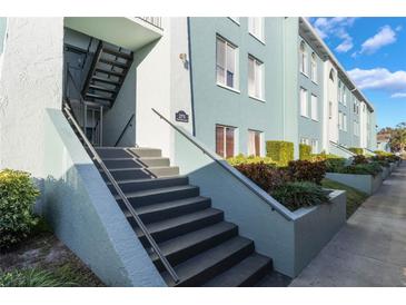 Exterior of a light teal building with stairs and landscaping at 275 114Th N Ave # 2, St Petersburg, FL 33716