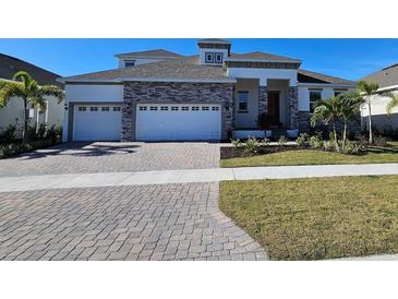 Two-story home with stone accents and three-car garage at 1078 Signet Dr, Apollo Beach, FL 33572