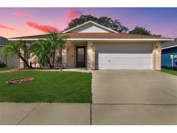 Charming one-story home with a well-manicured lawn and two-car garage at 15427 Winter Breeze Ln, Wimauma, FL 33598