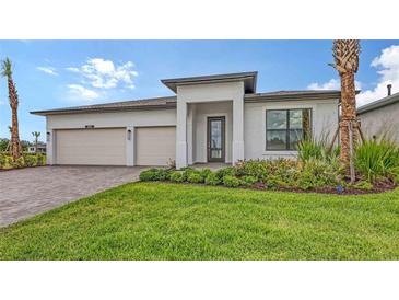 Beautiful single-story home with a manicured lawn, attached garage, and lovely landscaping at 14451 Coastal Woodland Ln, Parrish, FL 34219