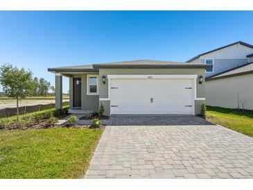 Charming single-Gathering home with a well-maintained lawn and a paved driveway leading to a two-car garage at 1876 Brekey Way, Zephyrhills, FL 33541