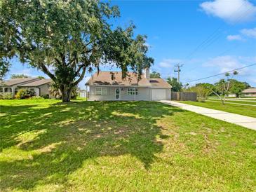 Charming single-story home featuring a sprawling green lawn, mature tree, and a welcoming front porch at 4000 Barbary Ln, North Port, FL 34287