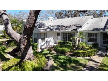 Well-maintained single-story home with lovely landscaping, shrubs and walkway at 4215 Edgewood Dr, Holiday, FL 34691