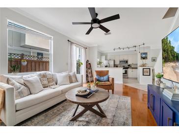 Bright living room featuring a comfortable sofa, ceiling fan, and an open floor plan to the modern kitchen at 2607 W Cleveland St # B, Tampa, FL 33609