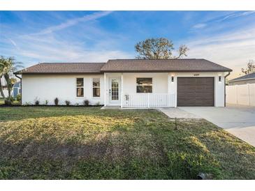 Charming single-story home featuring a manicured lawn, white picket fence, and attached garage at 4107 Mulgrave Ave, North Port, FL 34287