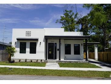 Charming single-story home with modern design elements, manicured lawn, and inviting entrance at 2604 E 11Th Ave, Tampa, FL 33605