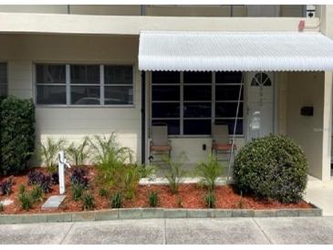 Charming condo entrance featuring a white awning and neatly landscaped garden at 4143 57Th N St # 502, Kenneth City, FL 33709