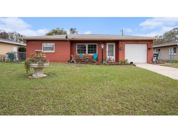 Charming single-story red brick home featuring a well-manicured lawn and inviting curb appeal at 1768 Suffolk Dr, Clearwater, FL 33756