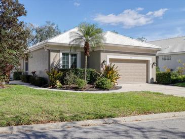 Charming home features an attached garage, manicured lawn, and mature landscaping at 5011 88Th E St, Bradenton, FL 34211