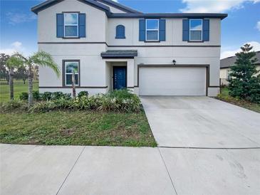 Charming two-story home with a well-manicured lawn, attached garage, and contrasting shutters at 36880 Precita Ter, Zephyrhills, FL 33542