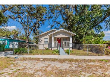 Charming single-story home featuring a red front door and a well-maintained fenced yard at 2634 E 38Th Ave, Tampa, FL 33610