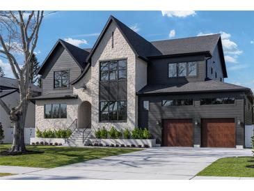 Stunning two-story home featuring a mix of stone and dark siding with a well-manicured front lawn at 1056 Snell Isle Ne Blvd, St Petersburg, FL 33704