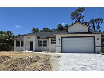 New construction shows a charming one-story home with a two-car garage and paver driveway at 2607 Seagull Ln, North Port, FL 34286