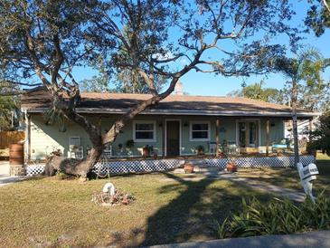 Charming single-story home with a covered porch, mature trees, and a well-manicured lawn at 4030 Worcester Rd, Sarasota, FL 34231