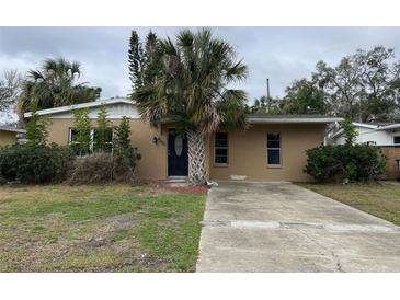 Charming single-story home with a stucco exterior, mature palm trees, and a spacious driveway at 4200 Huntington Ne St, St Petersburg, FL 33703