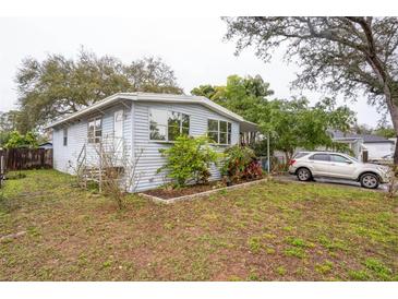 Charming single-story home with light blue siding, front yard landscaping, and a driveway at 7961 50Th N Ave, St Petersburg, FL 33709