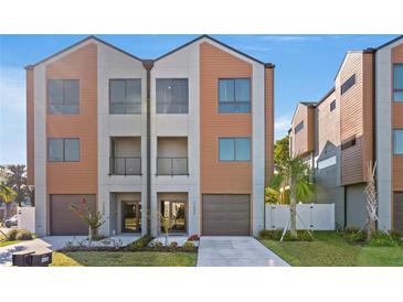 Modern townhome featuring a two-car garage, balcony, and neutral-toned facade at 2200 Bay Blvd # B, Indian Rocks Beach, FL 33785