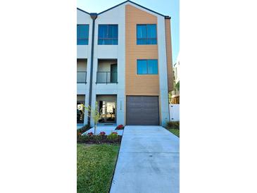 Modern three-story home featuring a contemporary design with large windows and a one car garage at 2200 Bay Blvd # B, Indian Rocks Beach, FL 33785