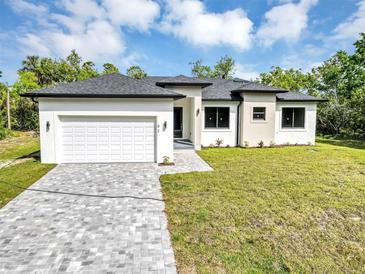 Stunning modern single-Gathering home with a two-car garage, landscaped yard, and a beautiful brick driveway at 82 Venango St, Port Charlotte, FL 33954