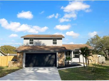 Beautiful two-story home with a two-car garage, stone accents, and a well-manicured lawn at 3305 Acapulco Dr, Riverview, FL 33578