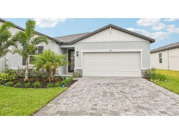 Charming single-Gathering home featuring a paved driveway, two-car garage, and meticulously landscaped front yard at 467 Sun Chaser Dr, Nokomis, FL 34275