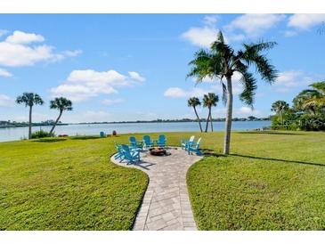 Inviting backyard with a firepit, seating, and waterfront views, perfect for outdoor relaxation and entertaining at 1690 Bayshore Dr, Englewood, FL 34223