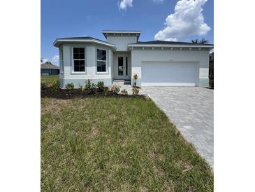 Charming single-story home featuring a well-manicured lawn and a gray paved driveway at 7343 N Ficus Tree, Punta Gorda, FL 33955
