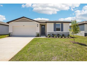 Charming single-story home with well-manicured lawn, attached garage, and welcoming entrance at 31610 Malbec Dr, Brooksville, FL 34602