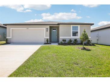 Charming single-story home with a well-maintained lawn and a welcoming front entrance at 31668 Wild Grape Ln, Brooksville, FL 34602