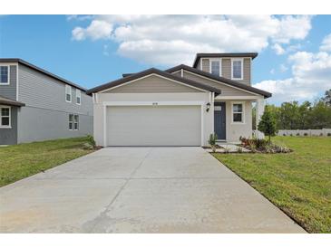 New home with a two-car garage, front yard landscaping, and modern architectural features at 3634 Moscato Dr, Brooksville, FL 34602