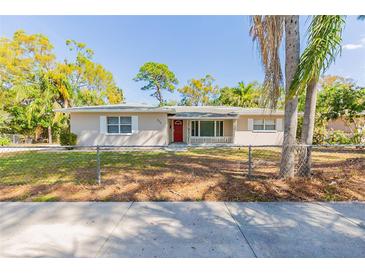 Charming single-story home with a red front door and a well-maintained lawn, located near lush trees at 777 27Th S Ave, St Petersburg, FL 33705