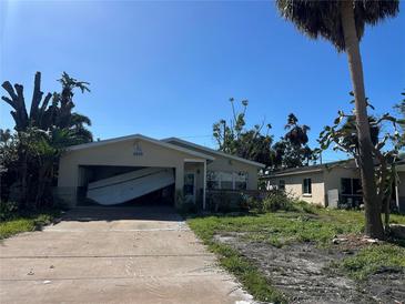 Hurricane damage to home; garage door has failed and debris is scattered in the yard at 1810 New Hampshire Ne Ave, St Petersburg, FL 33703