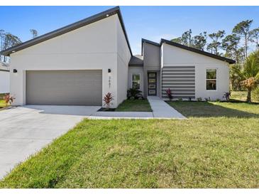 Charming modern home showcasing a two-car garage, clean lines, and contemporary design at 24520 Kingsway Cir, Punta Gorda, FL 33983